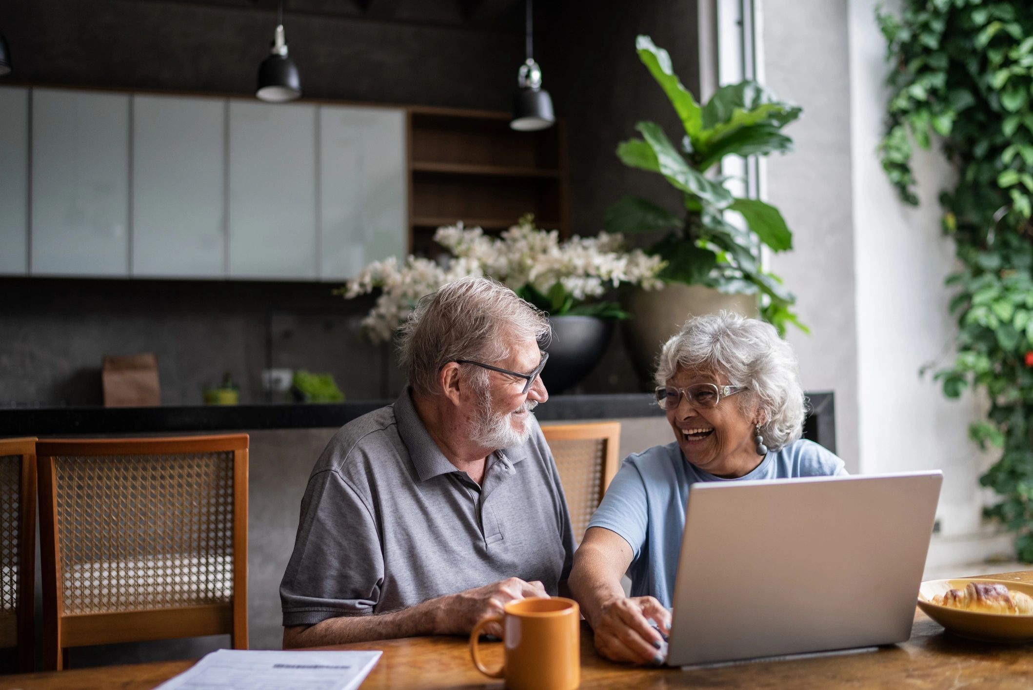Senior couple reviewing finances on a laptop at home