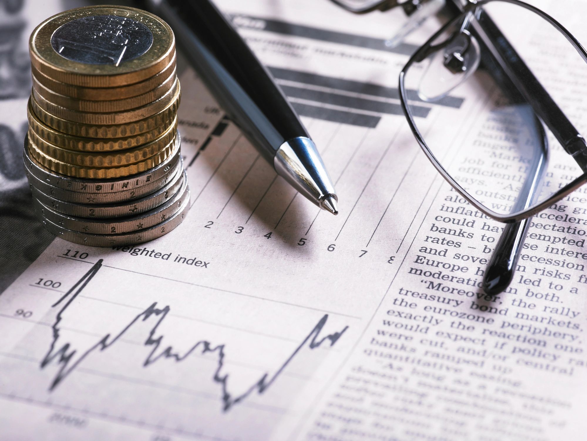 Financial chart with coins and pen